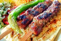 A plate serving of Adana Kebab and accompaniments
