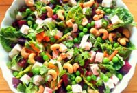 A bowl of salad taken from above. Pea and feta cheese with beetroot and cashews.