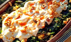 Cooked spinach borani topped with yoghurt and walnuts